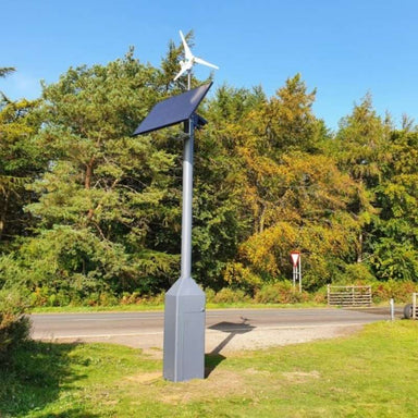 Marlec Rutland 1200x Land-Based Wind Turbine with MPPT Controller 12V with solar panel on a grassy area with trees in the background