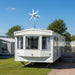 White caravan with a wind turbine on a sunny day